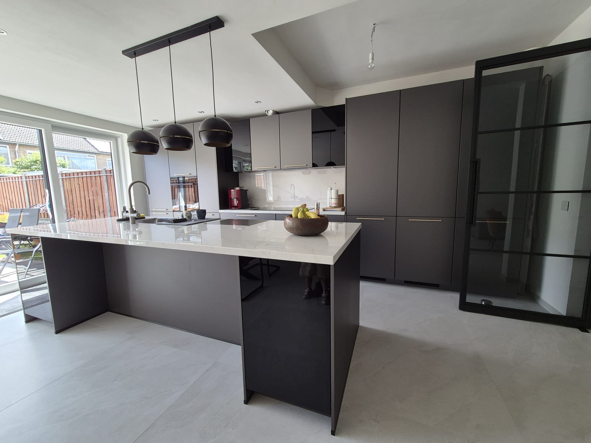 Luxury dark kitchen renovation with island and pendant lights by Construxx in Veldhoven